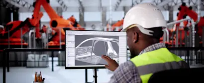 Lagermitarbeiter mit Helm & Schutzweste bedient digitalen Produktkonfigurator zur Variantenplanung 