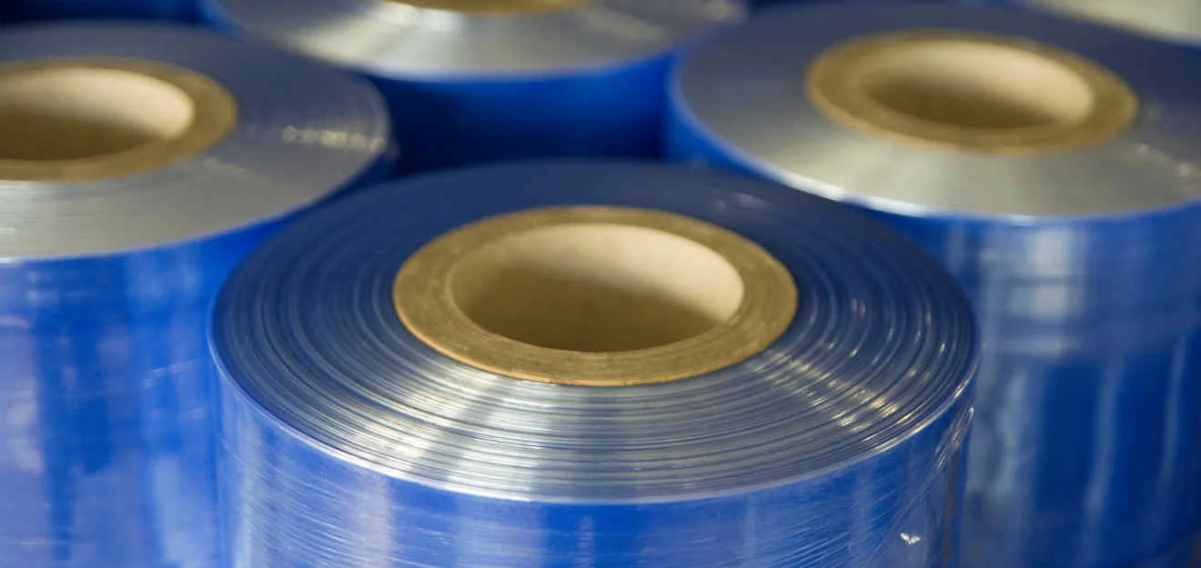 Kunststoff-Folienrollen für die Produktion bei Oldenburg Kunststoff-Technik Nahaufnahme mehrerer blauer Kunststoff-Folienrollen mit Kartonkernen; Licht spiegelt