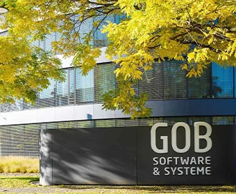 Main entrance of the GOB Software & Systeme GmbH building Front view of the GOB building with trees with autumnal yellow leaves