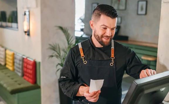 Waiter who operates a cash register in a restaurant