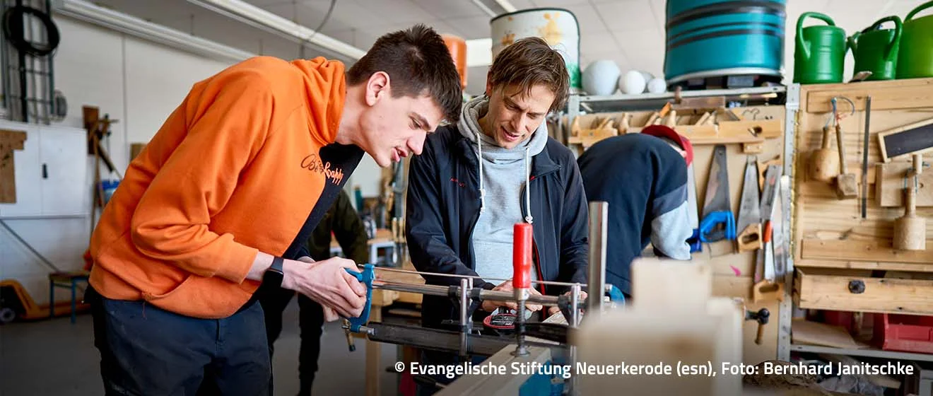 Werkstattalltag bei der esn – Copyright: Evangelische Stiftung Neuerkerode, Foto: Bernhard Janitschke Zwei Männer arbeiten gemeinsam in einer Werkstatt an einem technischen Modell.