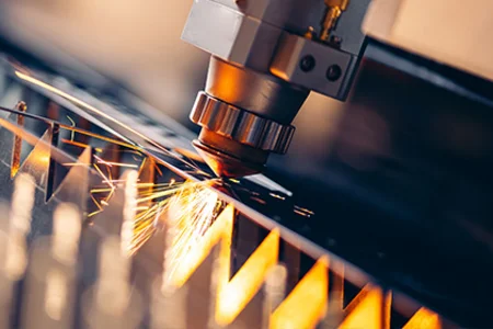 Laserschneidanlage schneidet ein Metallblech mit hoher Präzision, während helle Funken sprühen