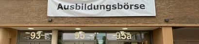 Banner „Ausbildungsbörse“ am BCM-Eingang – Ausbildungsmesse Moers 2025 Fassade mit großem Banner „Ausbildungsbörse“; Eingänge 93, 95 und 95a mit Glasfronten.