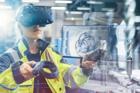 unitop für Industrieunternehmen – durchgängige Abläufe in der Fertigung Symbolbild: Person mit VR-Brille und Controllern in der Fertigung, im Hintergrund Maschinen.