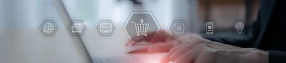 Hands typing on a laptop, icons for shopping cart, customers, channels – multichannel e-commerce.