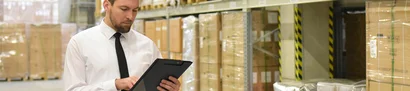 Warehouse manager checks processes on tablet | Warehouse management system (WMS) add-on for unitop Warehouse manager uses tablet to control warehouse processes via WMS system in high-bay warehouse