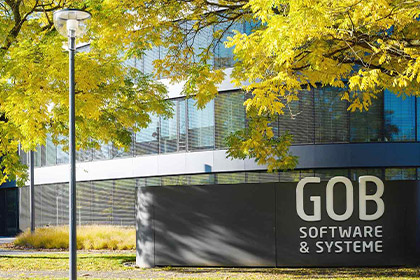 Haupteingang des Gebäudes der GOB Software & Systeme GmbH Frontansicht GOB-Gebäude mit Bäumen mit herbstlich-gelben Blättern